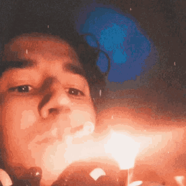 a man is blowing out a candle in front of his face