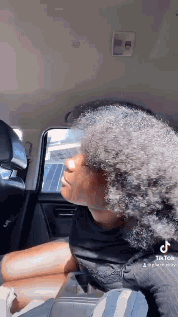 a woman is sitting in the back seat of a car with her legs crossed .