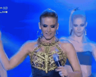 a woman singing into a microphone with the words hd live in the corner
