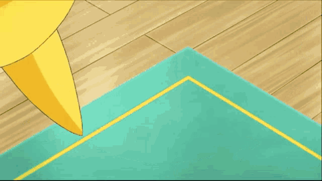 a yellow and blue cartoon character is sitting on a green mat