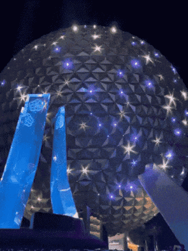 a large dome with purple lights on it is lit up