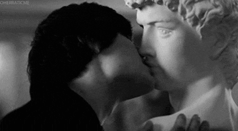 a man kissing a statue in a black and white photo .