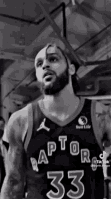 a black and white photo of a basketball player wearing a raptors jersey