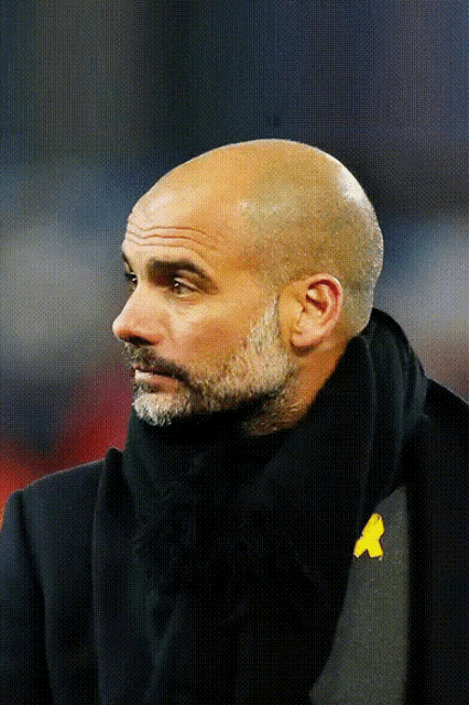 a man with a scarf around his neck has a yellow x on his shirt