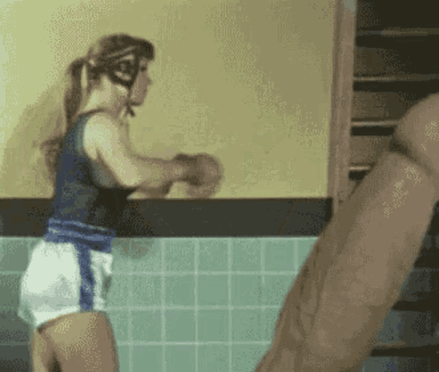 a woman in shorts is standing next to a man in a boxing ring .