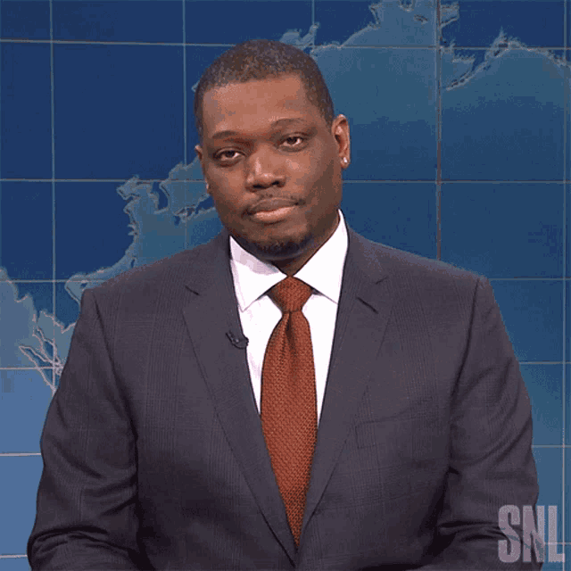 a man in a suit and tie with a snl logo