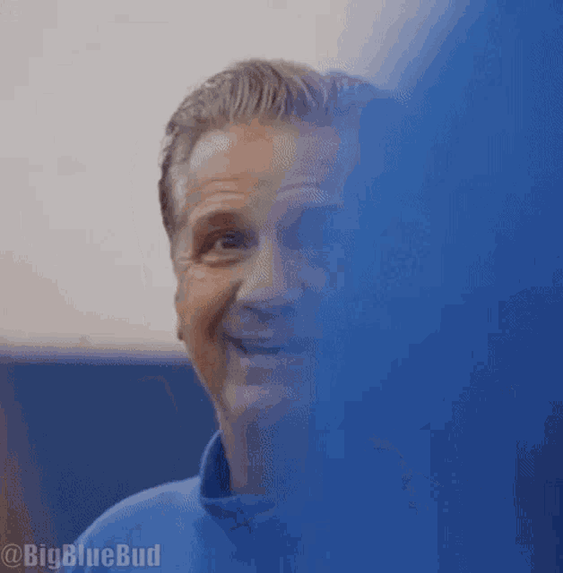 a close up of a man 's face with a blue jacket on .