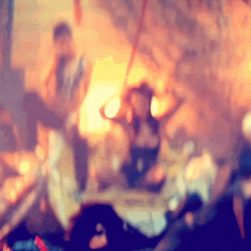 a blurred image of a group of people sitting around a fire