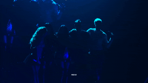 a group of people are standing in a dark room with a blue light behind them that says pubg uio
