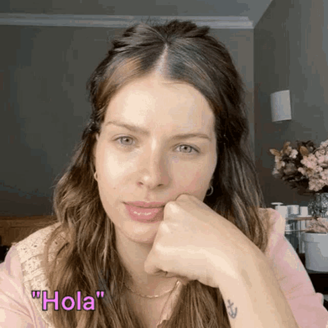 a close up of a woman 's face with the words " hola " on the bottom