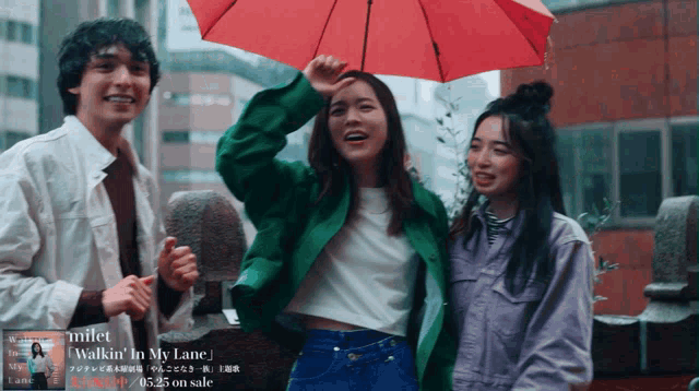 three people standing in the rain with a red umbrella that says " walkin ' in my lane " on the bottom