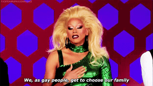 a drag queen is holding her chest and saying `` we , as gay people , get to choose our family ''