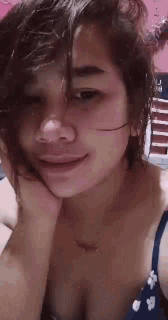 a close up of a woman with her hand on her face .