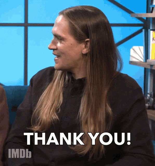 a man with long hair says " thank you "