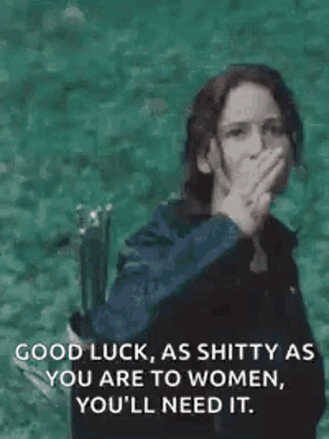 a woman is covering her mouth with her hand while holding a bow and arrow and a quote from hunger games .