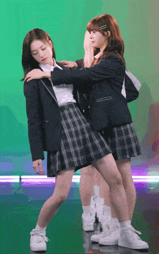 two girls in school uniforms are posing for a photo