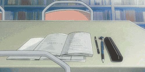 an open book is on a desk with a pen and pencil case