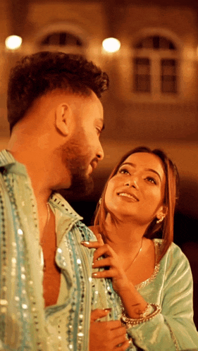 a man and a woman are looking at each other and the woman is smiling