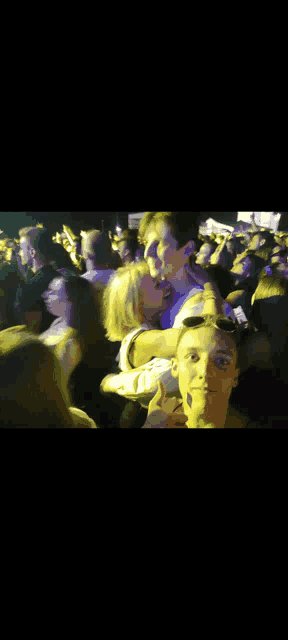 a man and a woman are kissing in a crowd of people