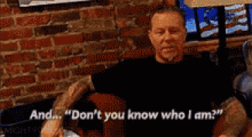 a man is sitting in front of a brick wall and saying " don 't you know who i am ? "
