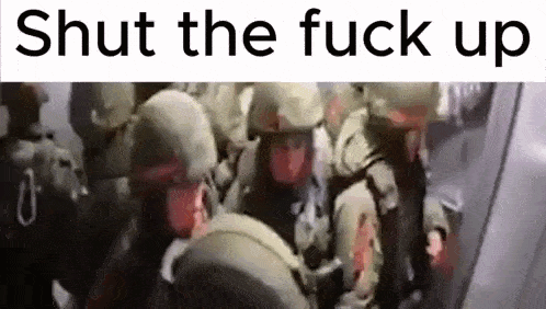 a group of soldiers are standing next to each other in a room with the words `` shut the fuck up '' written above them .