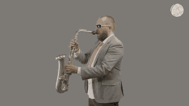 a man in a suit playing a saxophone with a gray background