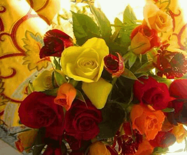 a bouquet of red and yellow roses with a yellow rose in the middle