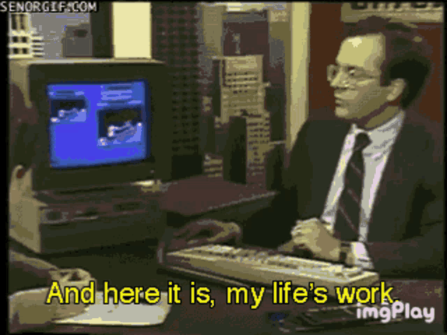 a man sitting in front of a computer with the words and here it is my life 's work on the bottom