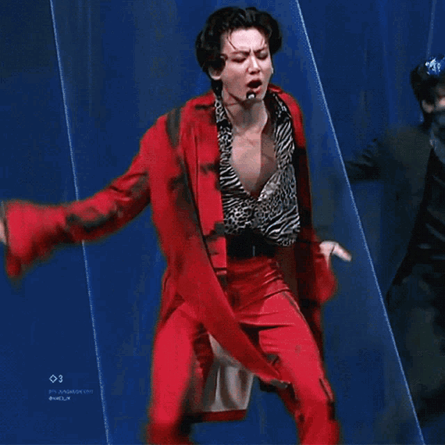 a man in a leopard print shirt and red pants