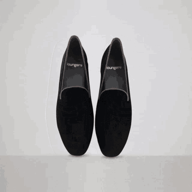 a pair of black loafers that say loungeers on them