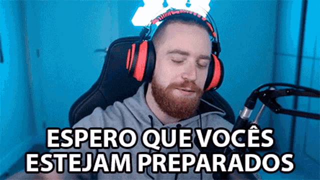 a man wearing headphones sitting in front of a microphone with the words espero que voces estejam preparados above him