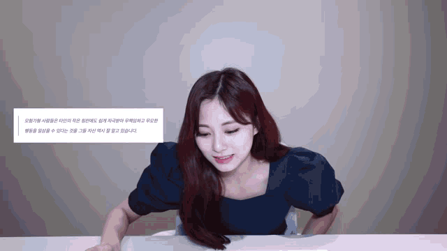 a girl with red hair is sitting at a table with a message in korean