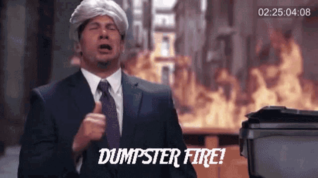 a man in a suit and tie says dumpster fire in front of a fire