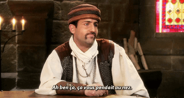a man sitting at a table with the words ah ben ca ca vous pendait au nez written below him