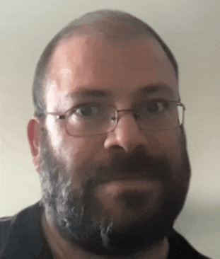 a man with a beard wearing glasses and a black shirt