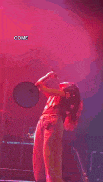 a woman is singing into a microphone on stage .