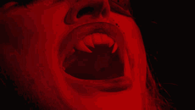 a close up of a person 's mouth with fangs in it