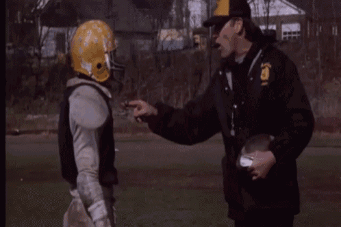 a football player wearing a yellow helmet with the letter g on it talks to a coach