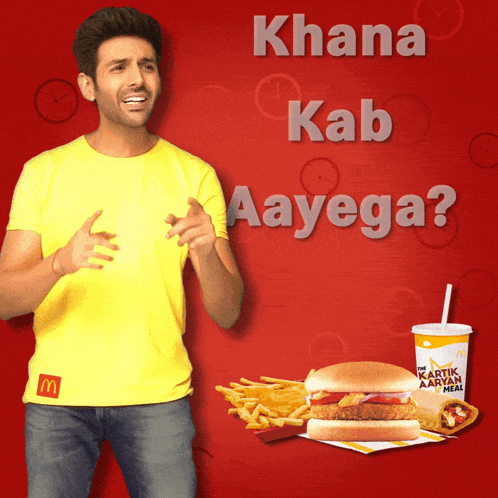 a man in a yellow shirt is standing next to a mcdonald 's advertisement