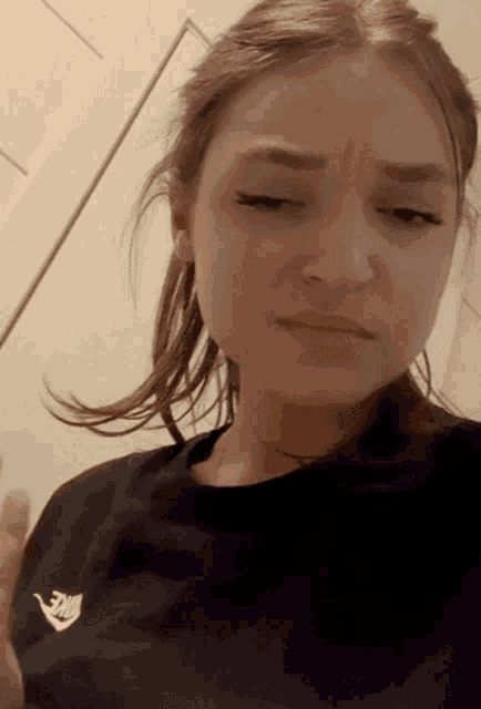 a woman is wearing a black nike shirt and making a funny face