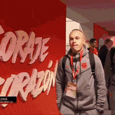 a man stands in front of a red wall that says " coraje "