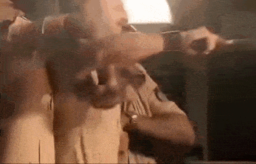 a man in a police uniform is holding a gun and pointing it at someone .