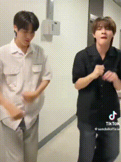 two young men are standing next to each other in a hallway and dancing .
