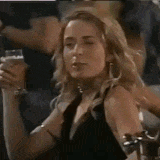 a woman in a blue shirt is holding a gun in her hand .