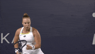 a tennis player stands in front of a biot sign