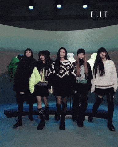 a group of girls are standing in front of a wall with the word elle on it