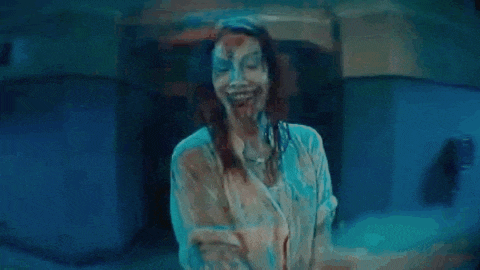 a close up of a woman with blood coming out of her mouth in a dark room .