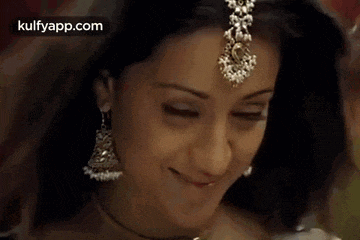 a close up of a woman wearing earrings and a headpiece .