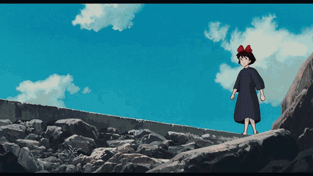 a girl with a red bow on her head is standing on a rocky hill