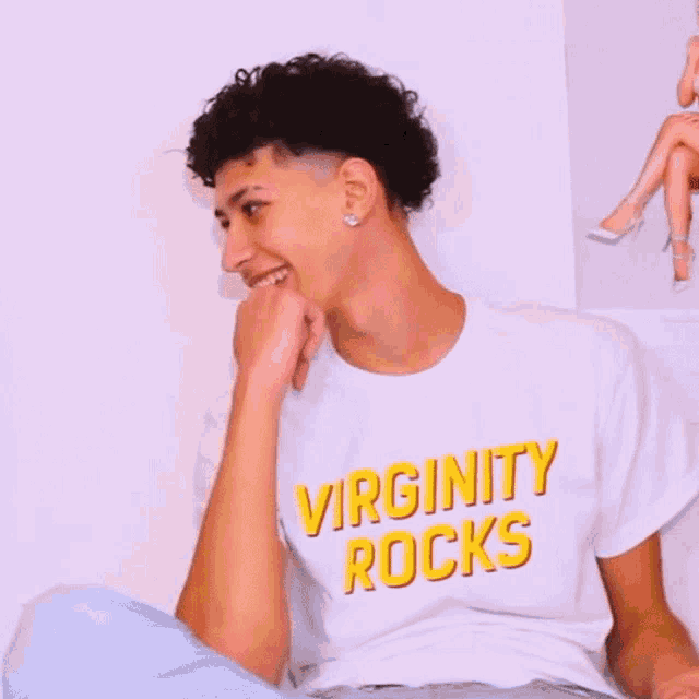 a young man wearing a virginity rocks shirt